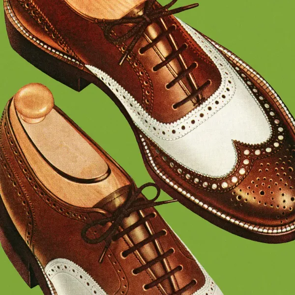 Brown and white men’s spectator shoes with brogue detailing – classic Kentucky Derby footwear style.