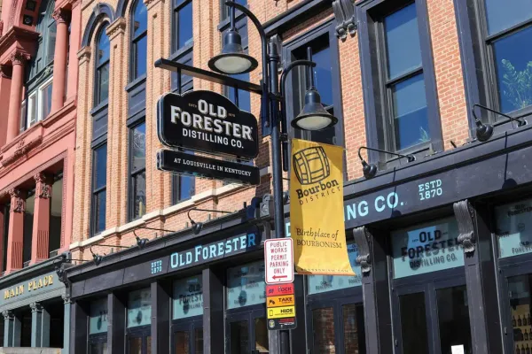 Old Forester Distilling Co. sign and Bourbon District banner on historic Whiskey Row in downtown Louisville, Kentucky – birthplace of bourbon.